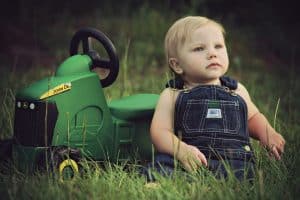 Bébé avec tracteur vert