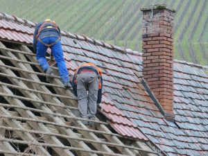 Deux hommes réparant une toiture