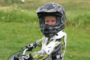 Petit garçon portant casque et faisant moto