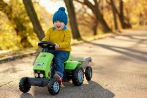Enfant faisant du tracteur à pédales en automne